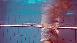 Cute redhead plays naked underwater